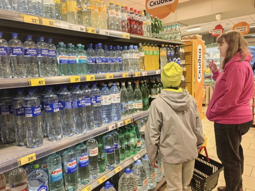 2 детей в магазине выбирают воду