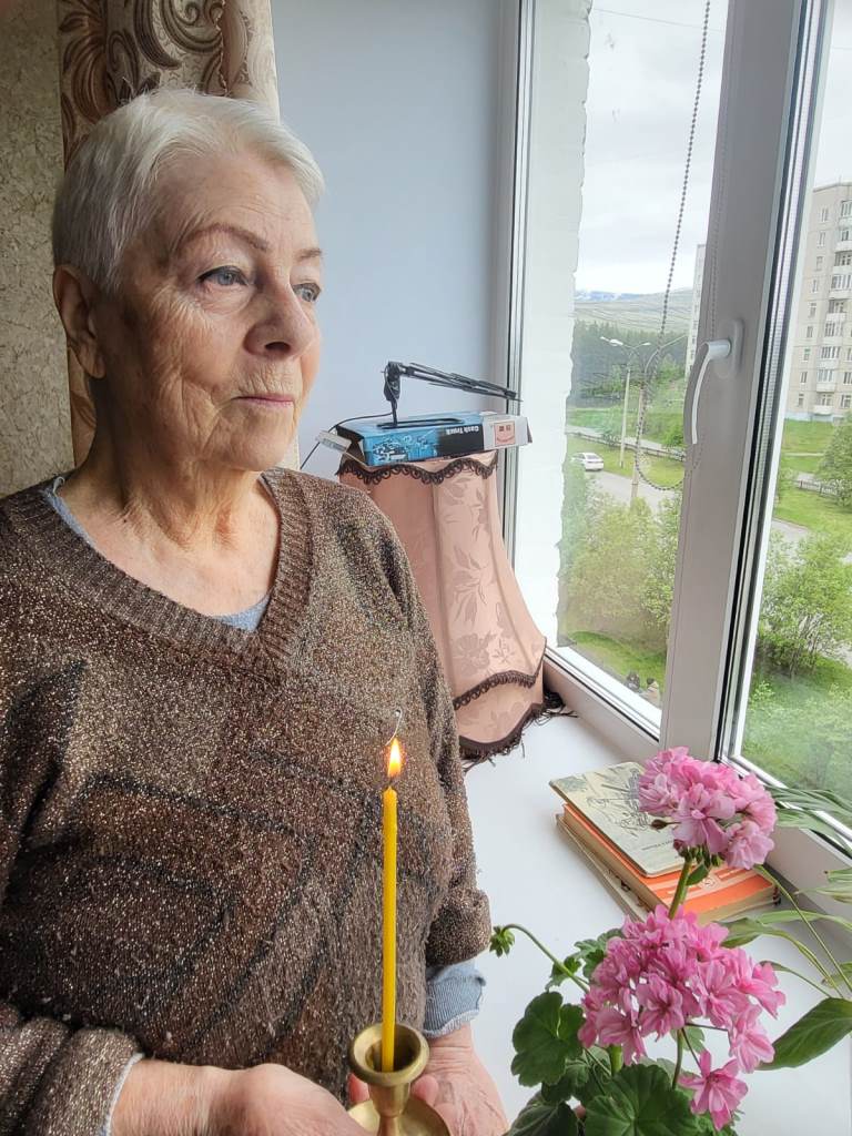 Женщины – получатели социальных услуг на дому держат в руке зажженные свечи