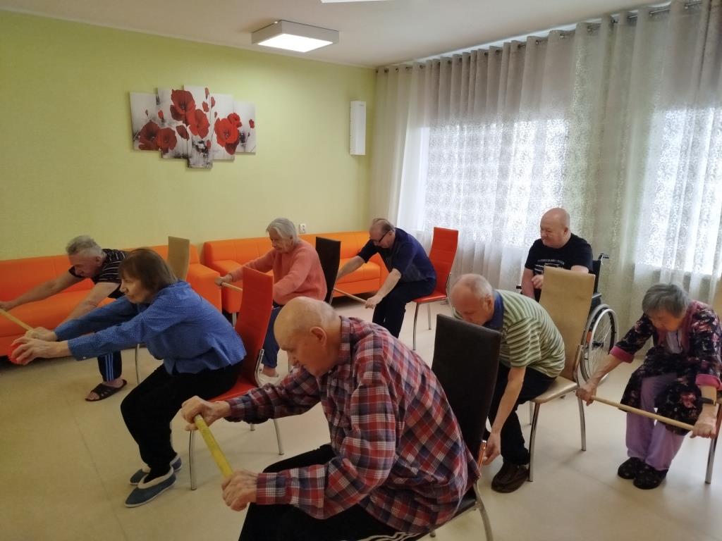 2.	Пожилые люди выполняют упражнение на растяжку с гимнастической палкой.
