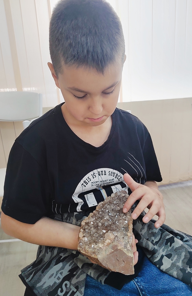 Воспитанник держит в руках экспонат