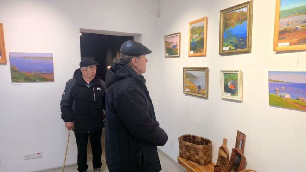 Мужчины, в количестве 2 человек, смотрят выставку картин в музейно-выставочном зале У Оленьей горы